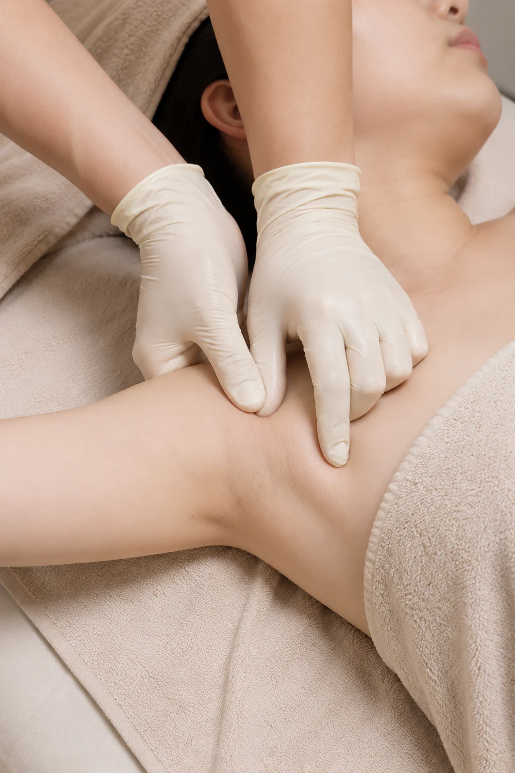 Relaxed neck and shoulder resting on a cream spa bed during lymphatic drainage